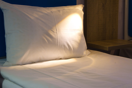 Bed in a hotel room at nightの写真素材