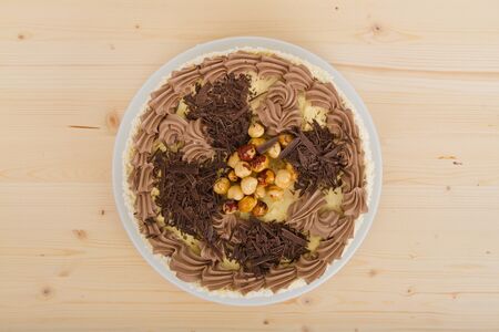 Cake with chocolate and nuts on a wooden tableの写真素材
