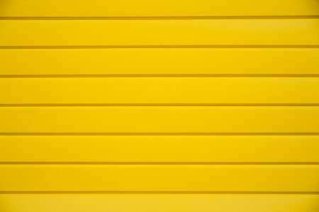 House siding. Yellow plastic panel siding texture.の写真素材