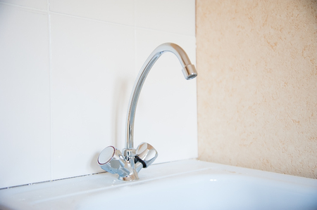 Close up old silver metal faucet in a kitchenの写真素材