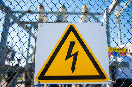 Electrical hazard sign placed on a metal fenceの写真素材