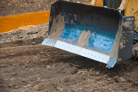 Excavator working with earth and sand in sandpit in highway construction site