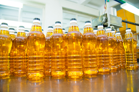 Vegetable oil production plant. Bottling line of vegetable oil in bottlesの写真素材