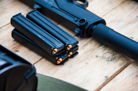 Close up gun with ammunition on wooden backgroundの写真素材