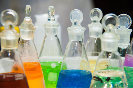 Chemical industry bulb with blue magenta pink liquid lab tubes stand on the table in the laboratory