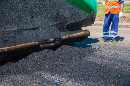 Workers on a road construction, industry and teamwork, new asphaltの写真素材