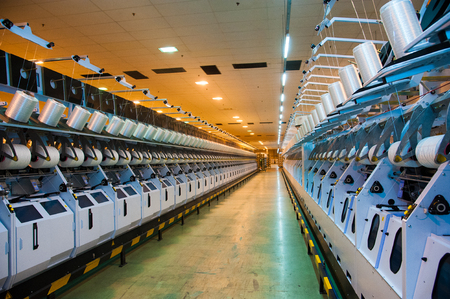 Industrial fabric production line. Weaving looms at a textile factoryの写真素材