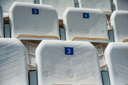 Tribune of fans at the stadium. Empty white seats in stadiumの写真素材