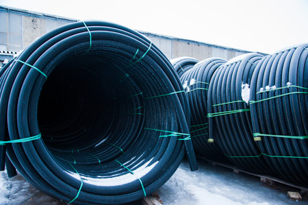 Warehouse of finished plastic pipes industrial outdoors storage site. Manufacture of plastic water pipes factory.の写真素材