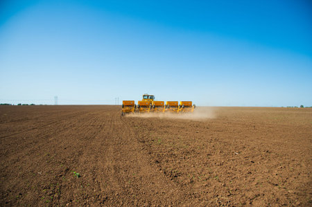 Farmer in tractor preparing farmland with seedbed for the next year