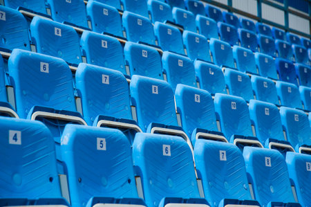 Tribune of fans at the stadium. Empty blue seats in stadium