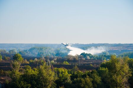 Firefighter airplane extinguishes a forest fire. Landscapeの写真素材