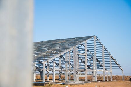 Steel frame workshop is under construction against a blue sky. New technology steel frame for constructionの写真素材