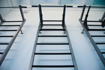 Wall bars in the gym. Wall bars in the school gymnastic hall. The image of a wall bar in a fitness hallの写真素材