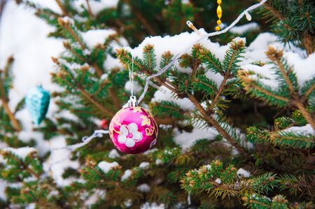 Nice decorations on a Christmas tree with snow outdoorsの写真素材