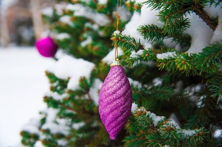 Nice decorations on a Christmas tree with snow outdoorsの写真素材