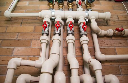 Copper valves, stainless ball valves, detector of water and plastic pipes of central heating system and water pipes in apartment during under renovation, remodeling and constructionの写真素材