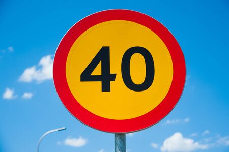 Road sign: speed limit 40 km/h. Road sign against a blue sky.の写真素材