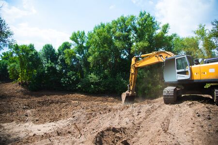 An excavator working removing earth on a construction siteの写真素材