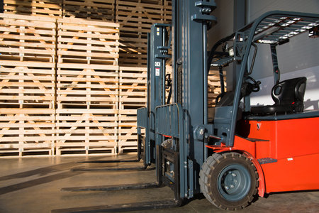 Forklift in a large warehouse for vegetable storage. Folded empty wooden boxes in warehouses, boxes...