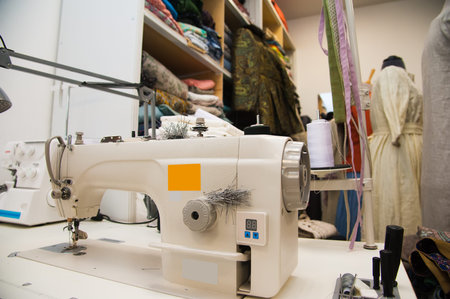 Old tailor workshop with sewing machine, fashion dummy, cloth and a new collection of women's...