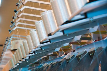 Industrial fabric production line. Weaving looms at a textile factoryの写真素材