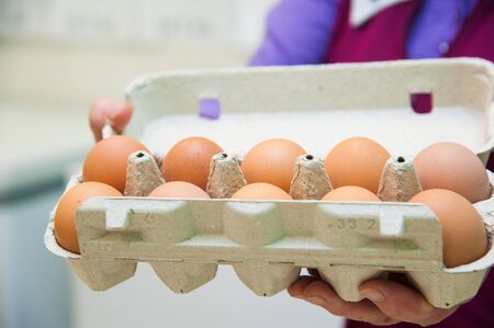 Packing eggs in the hands of a woman in a supermarketの写真素材
