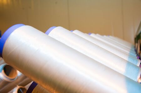 Industrial fabric production line. Weaving looms at a textile factoryの写真素材