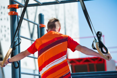 Young man exercising on horizontal bar outdoors. Calisthenics workout.