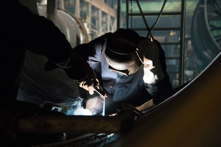 Sparks while welder uses torch to weldingの写真素材