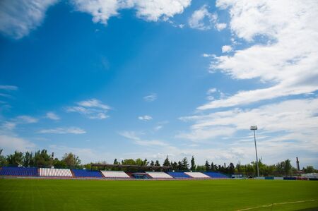 Outdoor stadium with overcast sky and green grassの写真素材