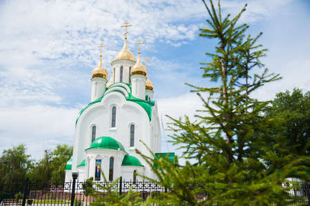 Golden domes church with a cross on a background of blue skyの写真素材
