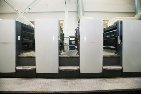 Printing presses at work in the printing. Printed sheets of paper are served in the printing press