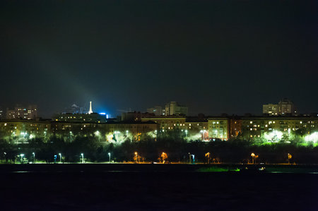 Panorama of the city at night. River in the foreground.
