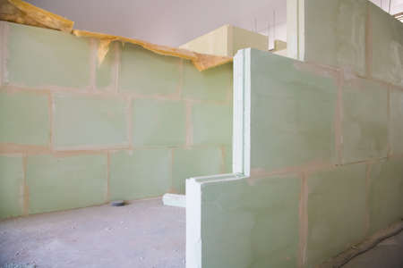Unfinished construction empty room. Walls from lightweight aggregate concrete blocks with empty doorframes, unfinished interior, house under constructionの写真素材