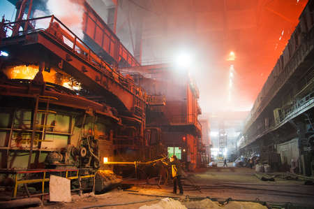 Metal structures and buildings of the old metallurgical plant inside and outside. The process of melting metal. Steelworker at work. Products of the metallurgical enterprise.の写真素材