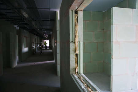 Unfinished construction empty room. Walls from lightweight aggregate concrete blocks with empty doorframes, unfinished interior, house under constructionの写真素材