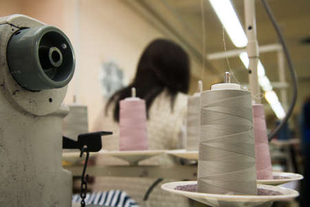 Garment factory. Sewing equipment, fabrics and threads. The process of tailoringの写真素材