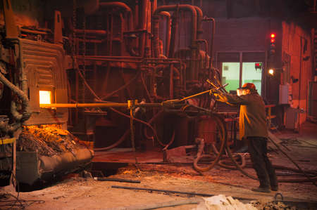 Metal structures and buildings of the old metallurgical plant inside and outside. The process of melting metal. Steelworker at work. Products of the metallurgical enterprise.の写真素材