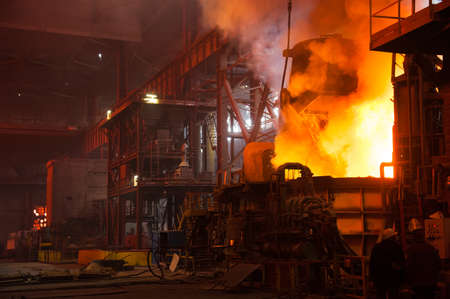 Metal structures and buildings of the old metallurgical plant inside and outside. The process of melting metal. Steelworker at work. Products of the metallurgical enterprise.の写真素材