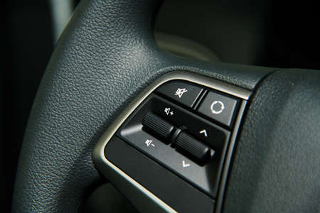 Car interior details close-up. Audio control buttons on the steering wheelの写真素材