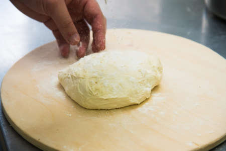 Professional chef prepares a closed meat pie in the restaurant kitchenの写真素材