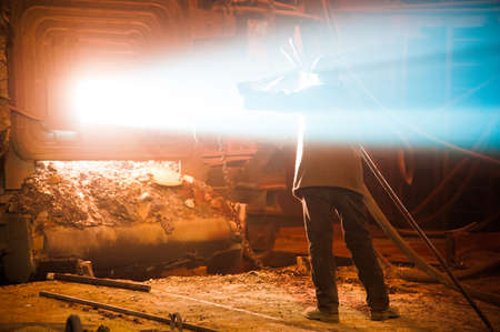 Metal structures and buildings of the old metallurgical plant inside and outside. The process of melting metal. Steelworker at work. Products of the metallurgical enterprise.の写真素材