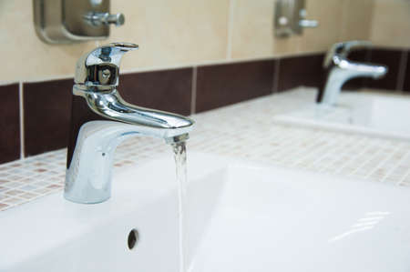 Row of modern white ceramic wash basin in public toilet or restaurant or hotel or shopping mallの写真素材