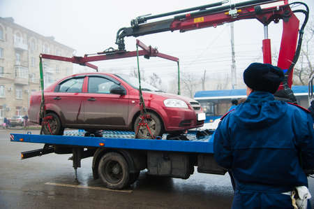 Traffic police officers on the street lifting the car on the tow truck for taking awayの写真素材