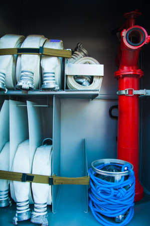 Compartment of rolled up fire hoses on a fire engine. Rescue fire truck equipmentの写真素材