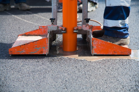 Checking the quality of road asphalt. Using a special tool, samples are taken to measure the thickness and quality of the asphalt surfaceの写真素材