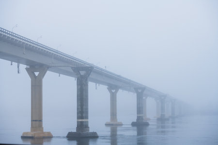 Autumn city landscape. Bridge over the river in heavy fogの写真素材