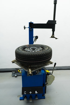 Car tires on the tire fitting machine at service stationの写真素材