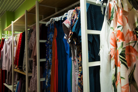 Colorful women's dresses on hangers in a retail shop